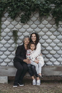 Portrait of multigenerational family sitting and smiling outside