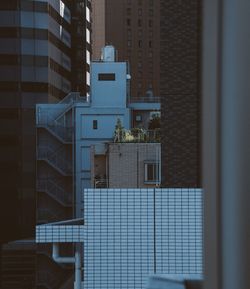 Buildings against sky seen through glass window