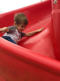 Boy enjoying on slide at playground
