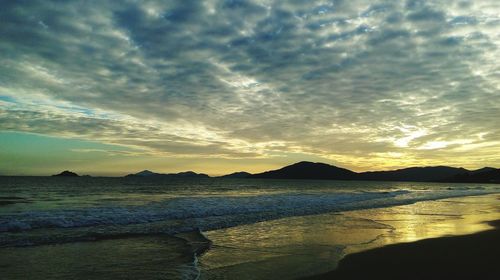 Scenic view of beach against dramatic sky