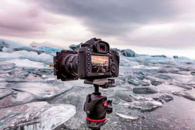 Close-up of camera on sea against sky