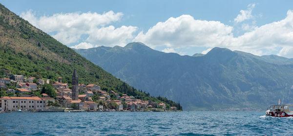 Scenic view of sea by townscape against sky