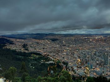 High angle view of illuminated cityscape against storm clouds