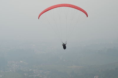 Person paragliding against sky