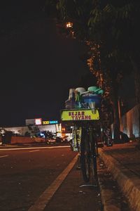 Road sign on street in city at night