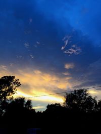 Low angle view of silhouette trees against sky at sunset