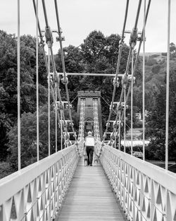 Rear view of people walking on footbridge