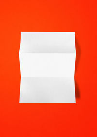 Directly above shot of white paper against orange background