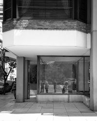 People on street amidst buildings in city