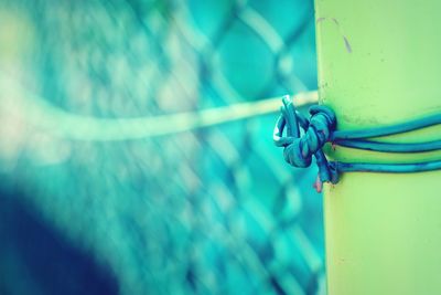 Close-up of rope tied on metal fence