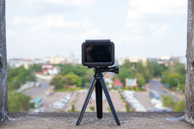 Close-up of camera photographing against sky