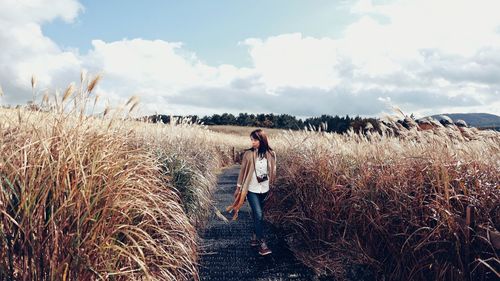 Woman standing on landscape against sky