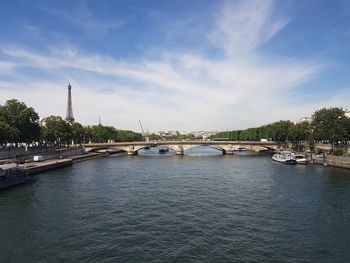 Arch bridge over river against sky in city