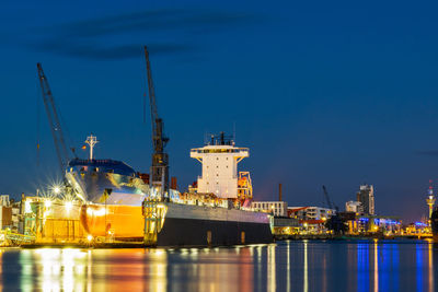 Illuminated commercial dock against sky at night