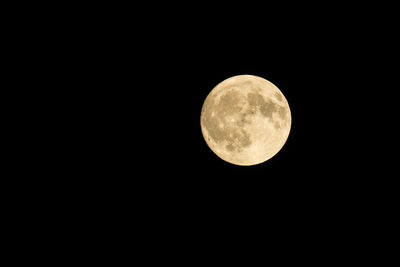 Low angle view of full moon against clear sky at night