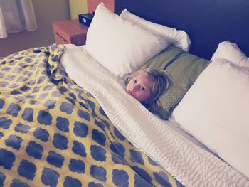 Portrait of girl resting on bed at home