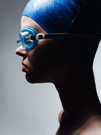 Close-up of woman against blue background