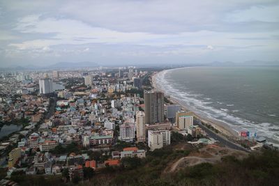 Aerial view of city against cloudy sky