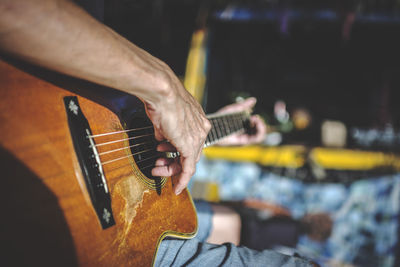 Cropped hand of man playing guitar