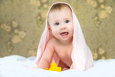 Happy baby girl with towel on head at home