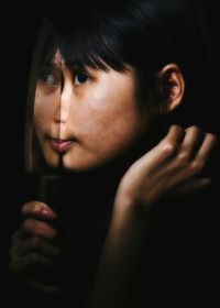 Close-up of woman looking away by glass window