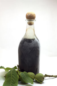 Close-up of glass bottle on table against white background