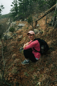 Man sitting on field in forest