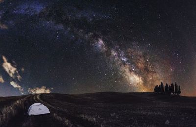 Scenic view of landscape against star field at night