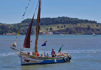 Boat sailing in sea against clear sky