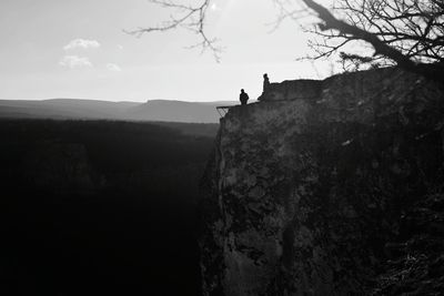 Distant view of people on rock against sky