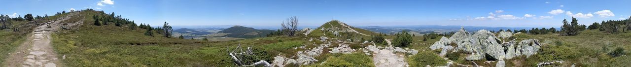Panoramic view of landscape and mountains against blue sky