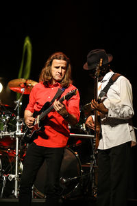 Young man playing guitar at music concert