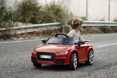 A girl riding a toy car