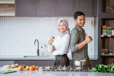 Portrait of young woman standing in kitchen