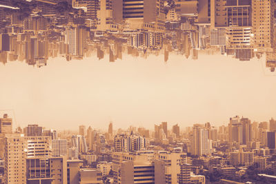 Aerial view of buildings in city against sky