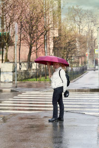 Full length of wet person walking on street