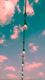 Low angle view of illuminated light bulbs against sky