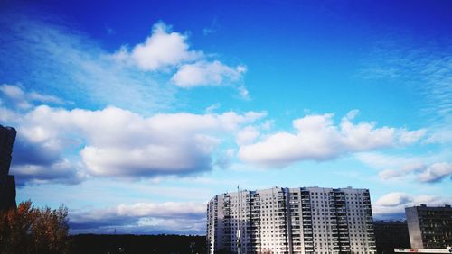 Low angle view of cityscape against blue sky
