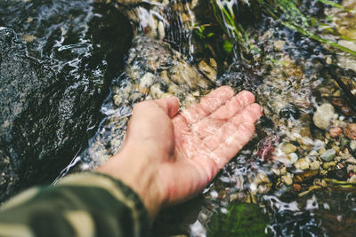 High angle view of human hand on rock