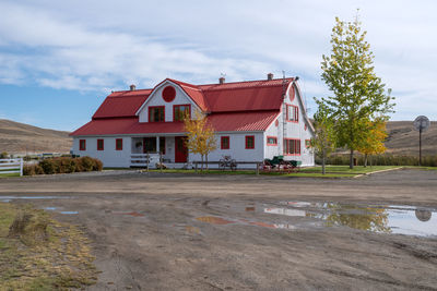 Houses by road against sky in city