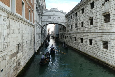 People on boat in canal along buildings