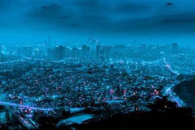 High angle view of illuminated cityscape against sky at night