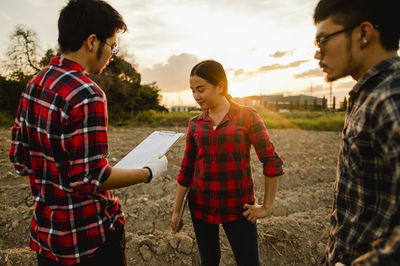 Young couple standing against sky