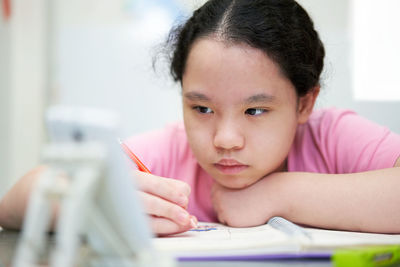 Close-up of cute girl studying at home