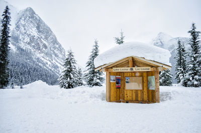 Built structure on snow covered land against mountain