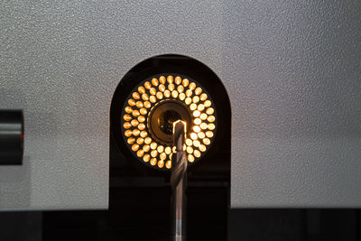 Low angle view of illuminated lamp on wall in building