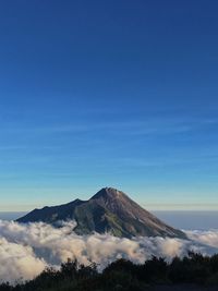 Scenic view of volcanic mountain against blue sky