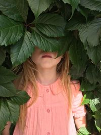 Close-up of a girl with green leaves