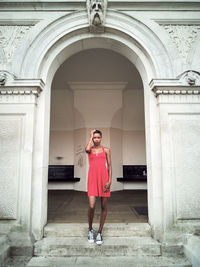 Young woman standing at entrance of building