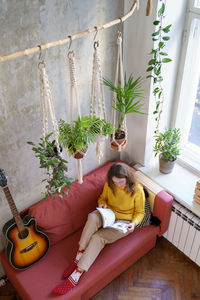 High angle view of woman relaxing by potted plants